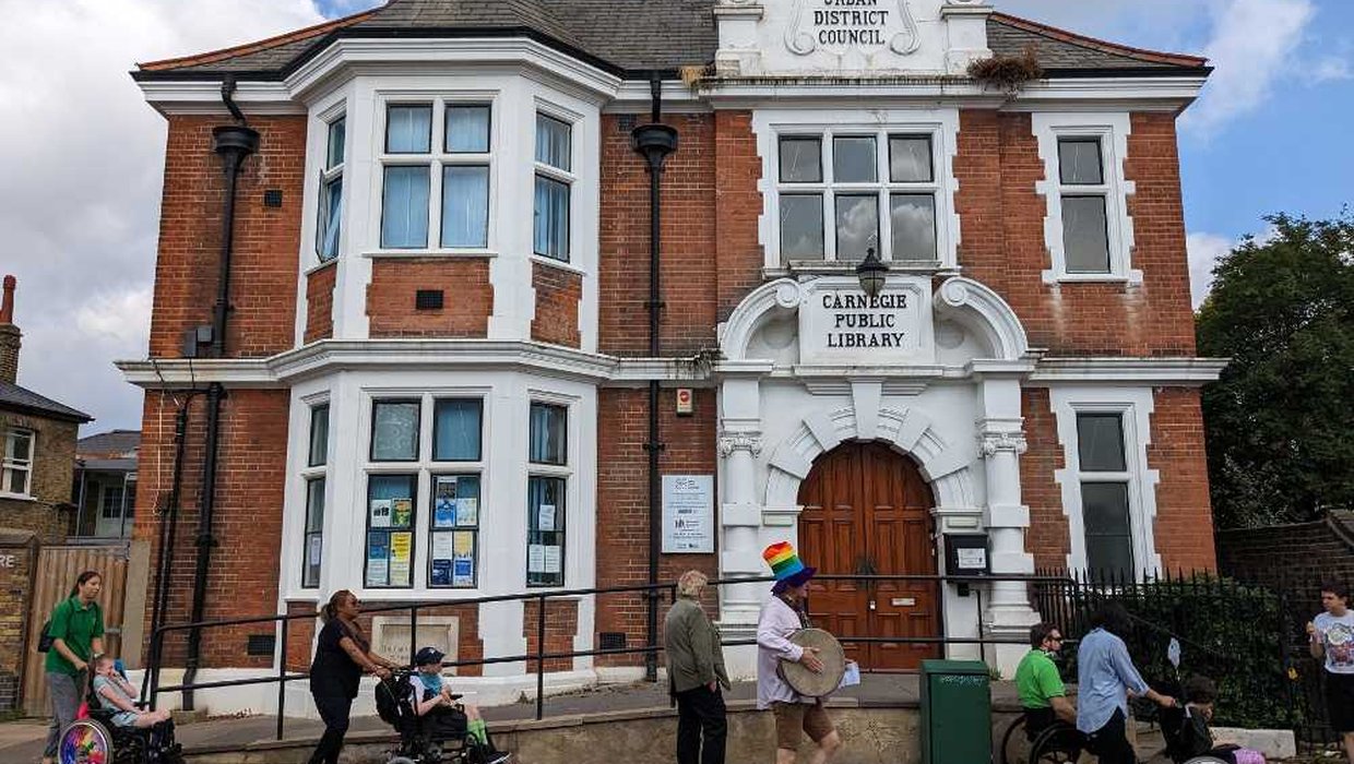 A wheelchair parade go past an old looking building